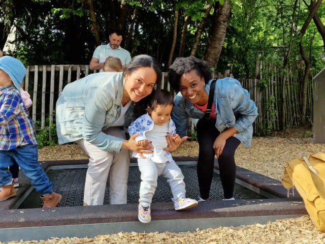 Two women in their early 30s having fun together and playing with a small child. Showing friendship and support.